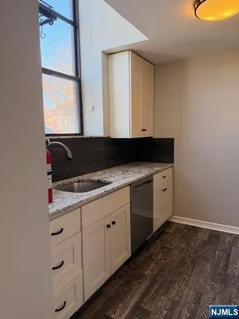 a bathroom with a granite countertop sink mirror vanity and toilet