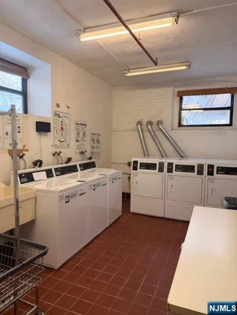 a kitchen with a sink a stove top oven and white cabinets