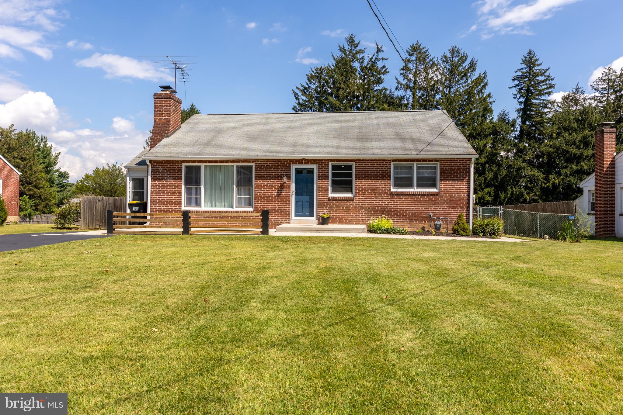 a front view of house with outdoor seating and green space