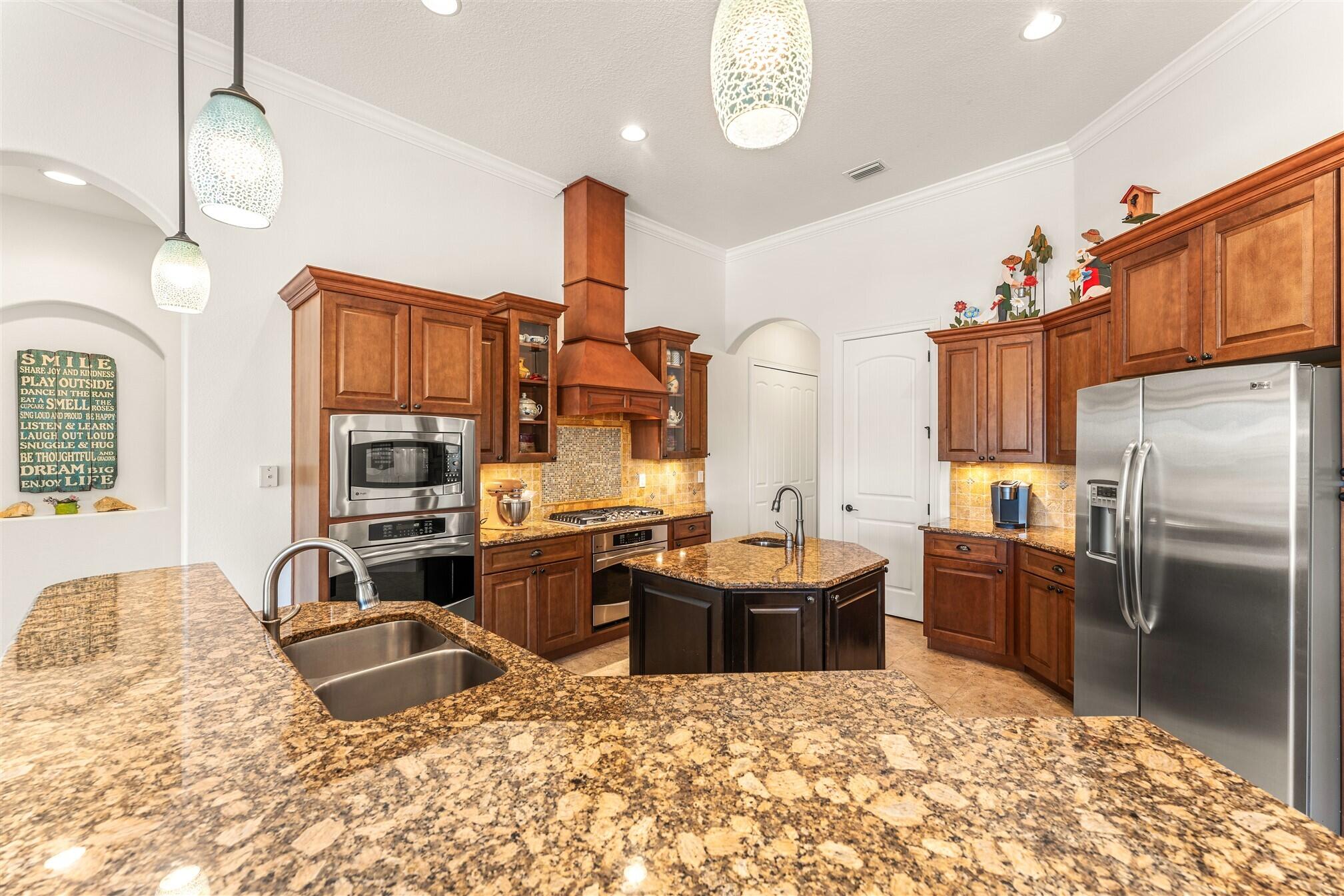 3210 Levanto Drive Melbourne, FL 32940 - Photo 35 of 76 a kitchen with stainless steel appliances kitchen island granite countertop a sink refrigerator and cabinets