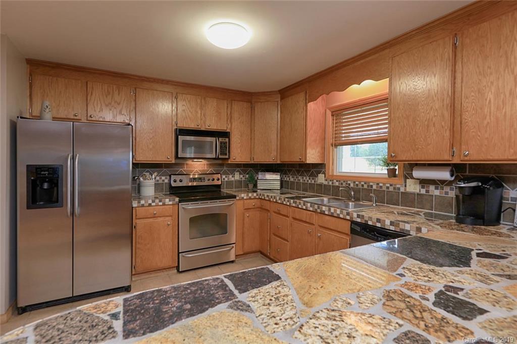 166 Stikeleather Road Stony Point, NC 28678 - Photo 18 of 48 a kitchen with granite countertop a refrigerator sink and microwave