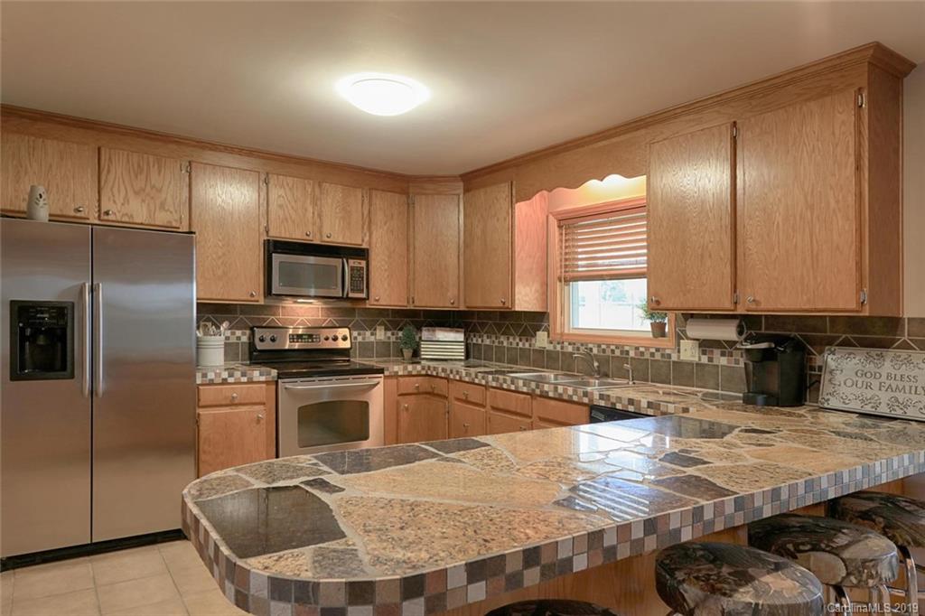 166 Stikeleather Road Stony Point, NC 28678 - Photo 19 of 48 a kitchen with kitchen island granite countertop a sink stove and refrigerator