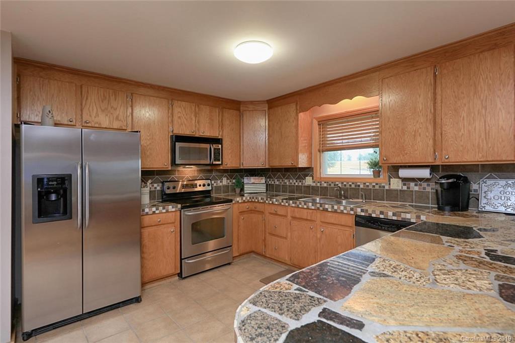 166 Stikeleather Road Stony Point, NC 28678 - Photo 23 of 48 a kitchen with granite countertop stainless steel appliances and wooden cabinets