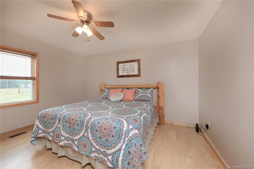166 Stikeleather Road Stony Point, NC 28678 - Photo 24 of 48 a bedroom with a bed and a chandelier