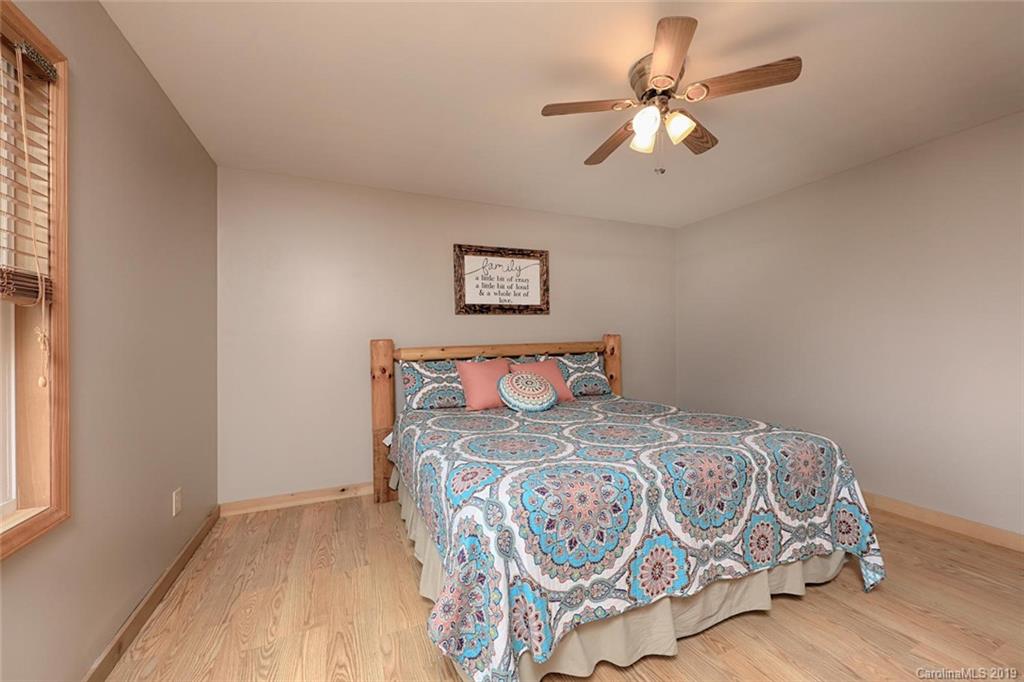 166 Stikeleather Road Stony Point, NC 28678 - Photo 25 of 48 a bedroom with a large bed and a chandelier