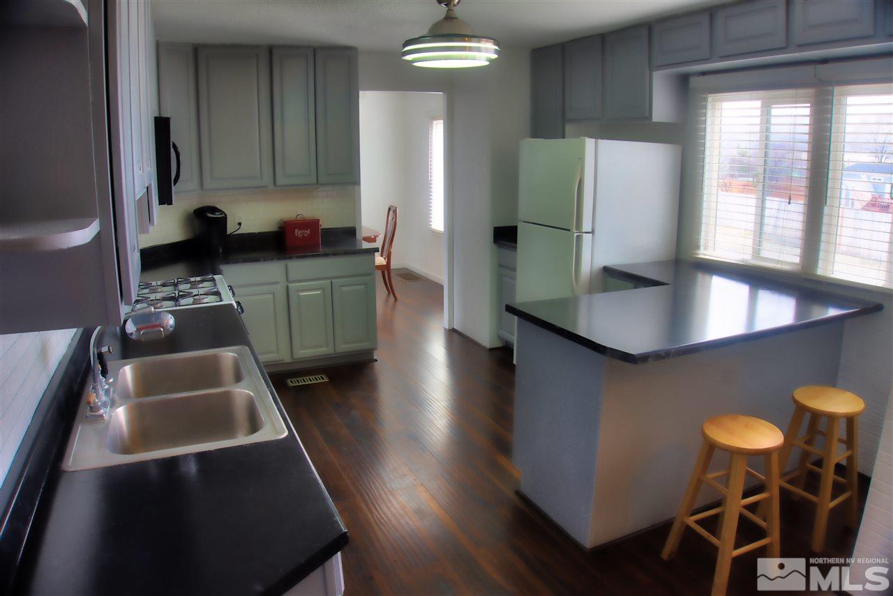 17745 Peacock Place Reno, NV 89508 - Photo 3 of 26 a kitchen with stainless steel appliances granite countertop a table chairs and a refrigerator