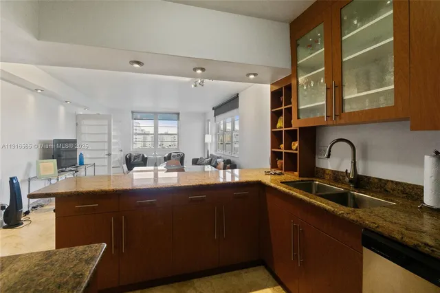 a kitchen with stainless steel appliances granite countertop sink stove top oven and cabinets