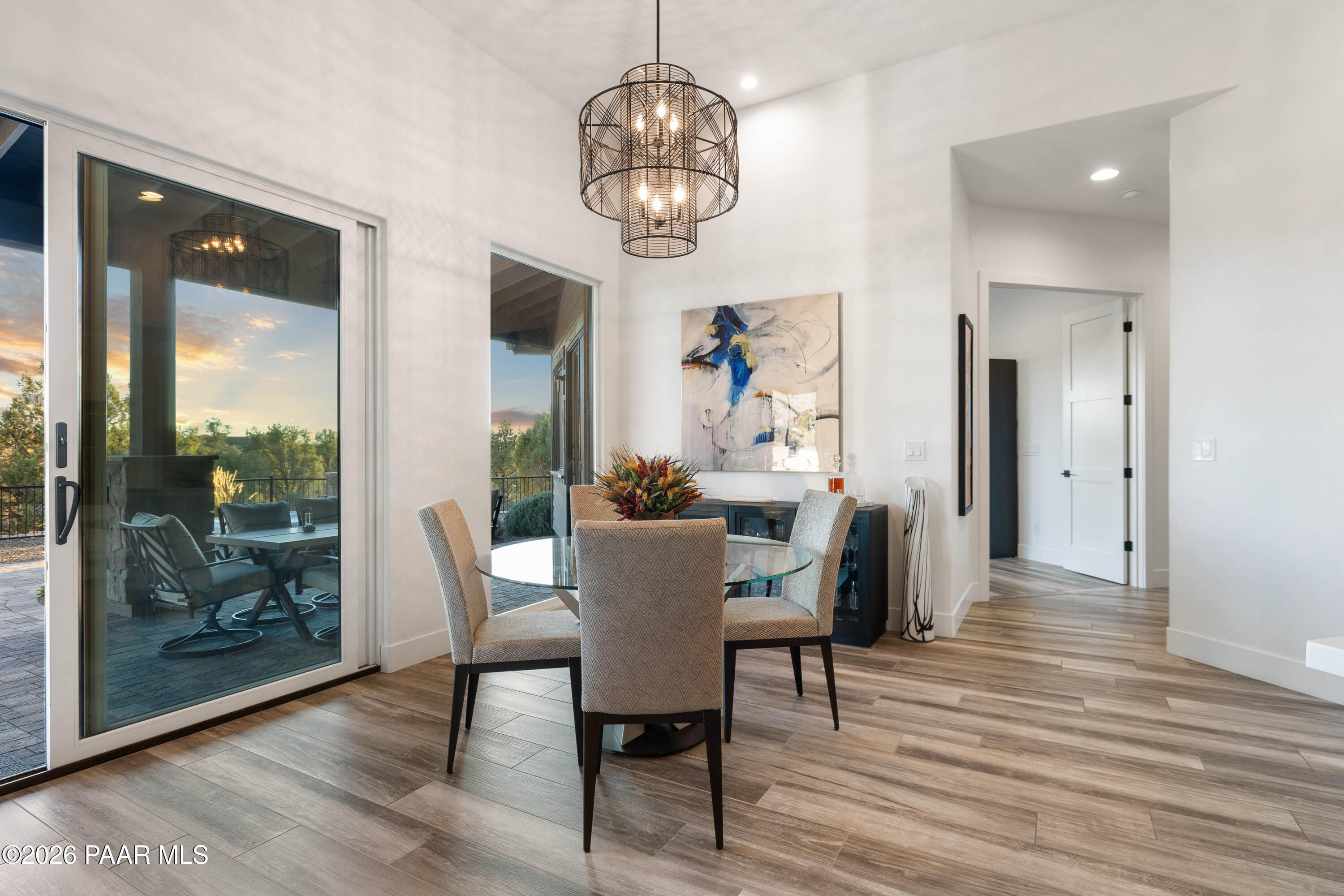 5475 West Three Forks Road Prescott, AZ 86305 - Photo 20 of 65 a dining room with wooden floor a chandelier a wooden table and chairs