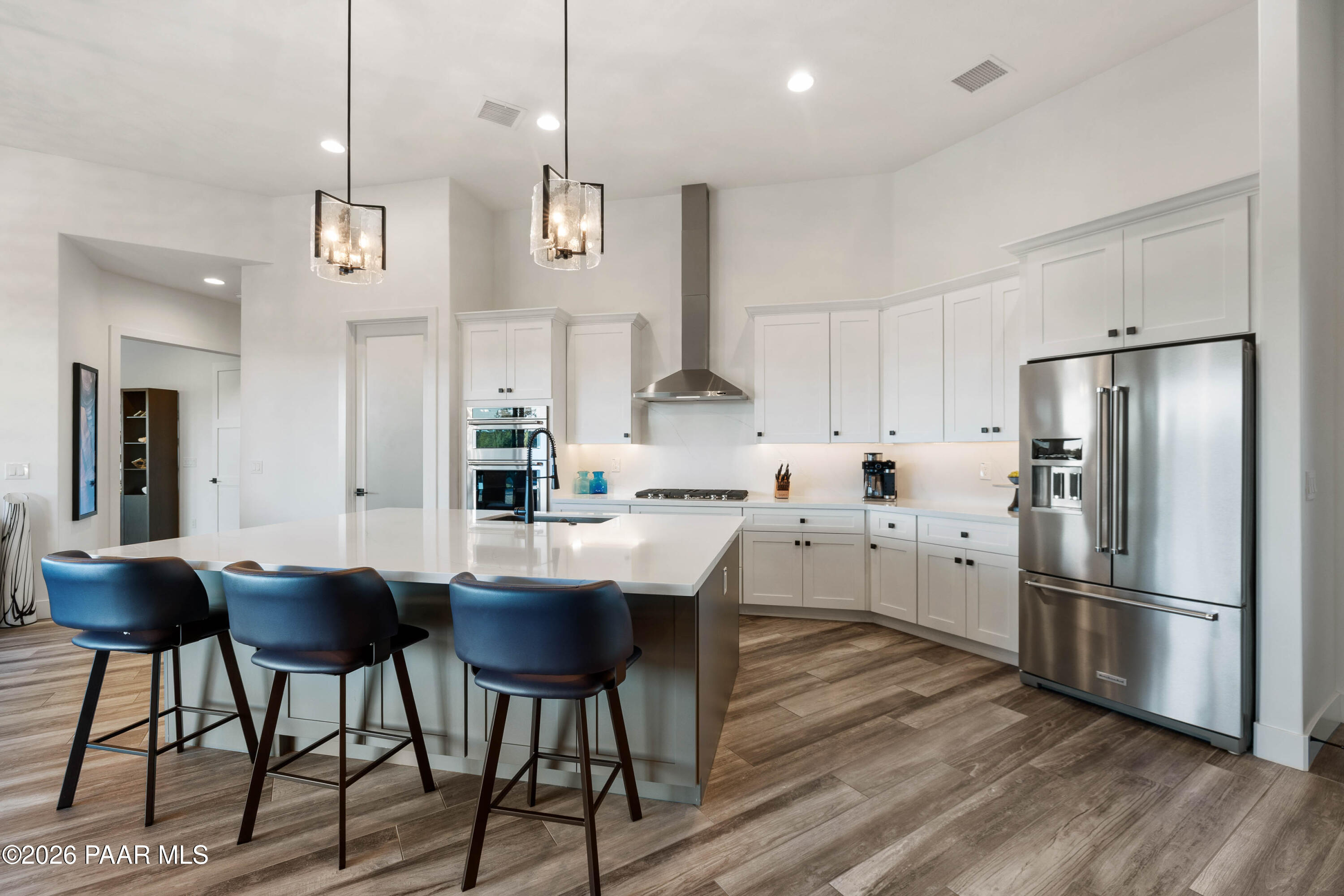 5475 West Three Forks Road Prescott, AZ 86305 - Photo 23 of 65 a kitchen with stainless steel appliances granite countertop a refrigerator a sink dishwasher a stove and white cabinets with wooden floor