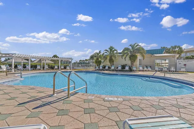 a view of a house with a swimming pool and sitting area