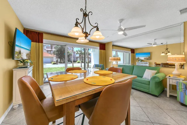 a view of a dining room with furniture a chandelier and a large window