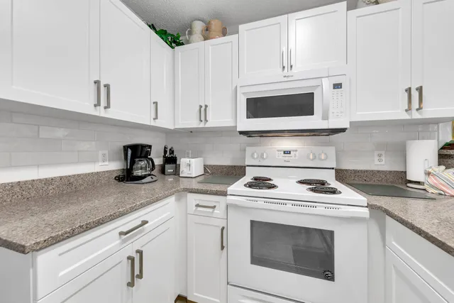 a kitchen with stainless steel appliances granite countertop a sink and a refrigerator