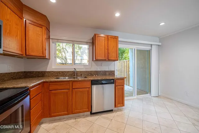 a kitchen with stainless steel appliances granite countertop a refrigerator and a sink
