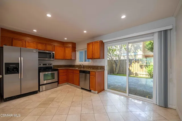 a kitchen with stainless steel appliances granite countertop a refrigerator and a sink