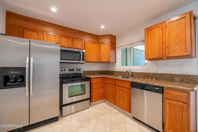 a kitchen with stainless steel appliances granite countertop a sink and a stove