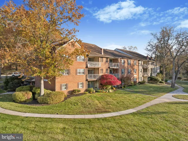 a view of a white house with a big yard and potted plants
