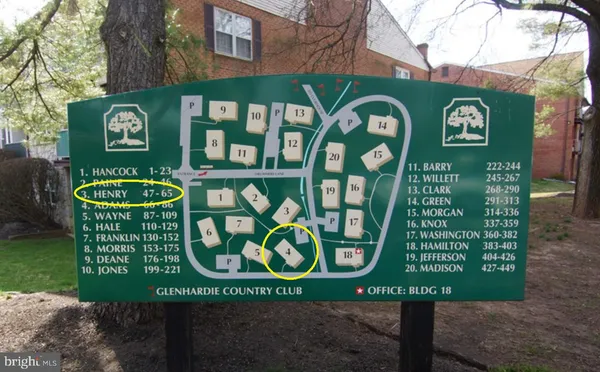 a front view of a building with garden and trees