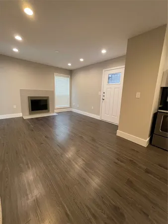 an empty room with wooden floor and fireplace