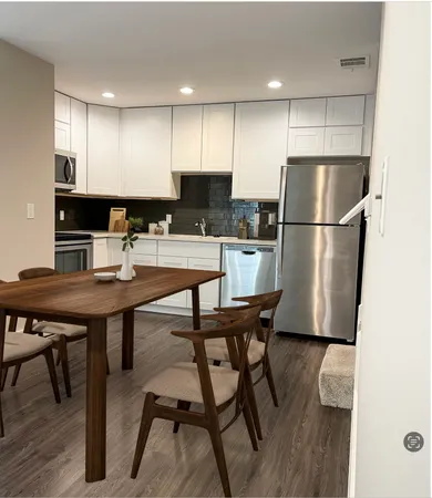 a kitchen with a table chairs refrigerator and microwave