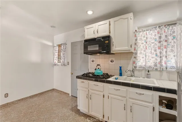 a kitchen with stainless steel appliances granite countertop a sink a stove and microwave