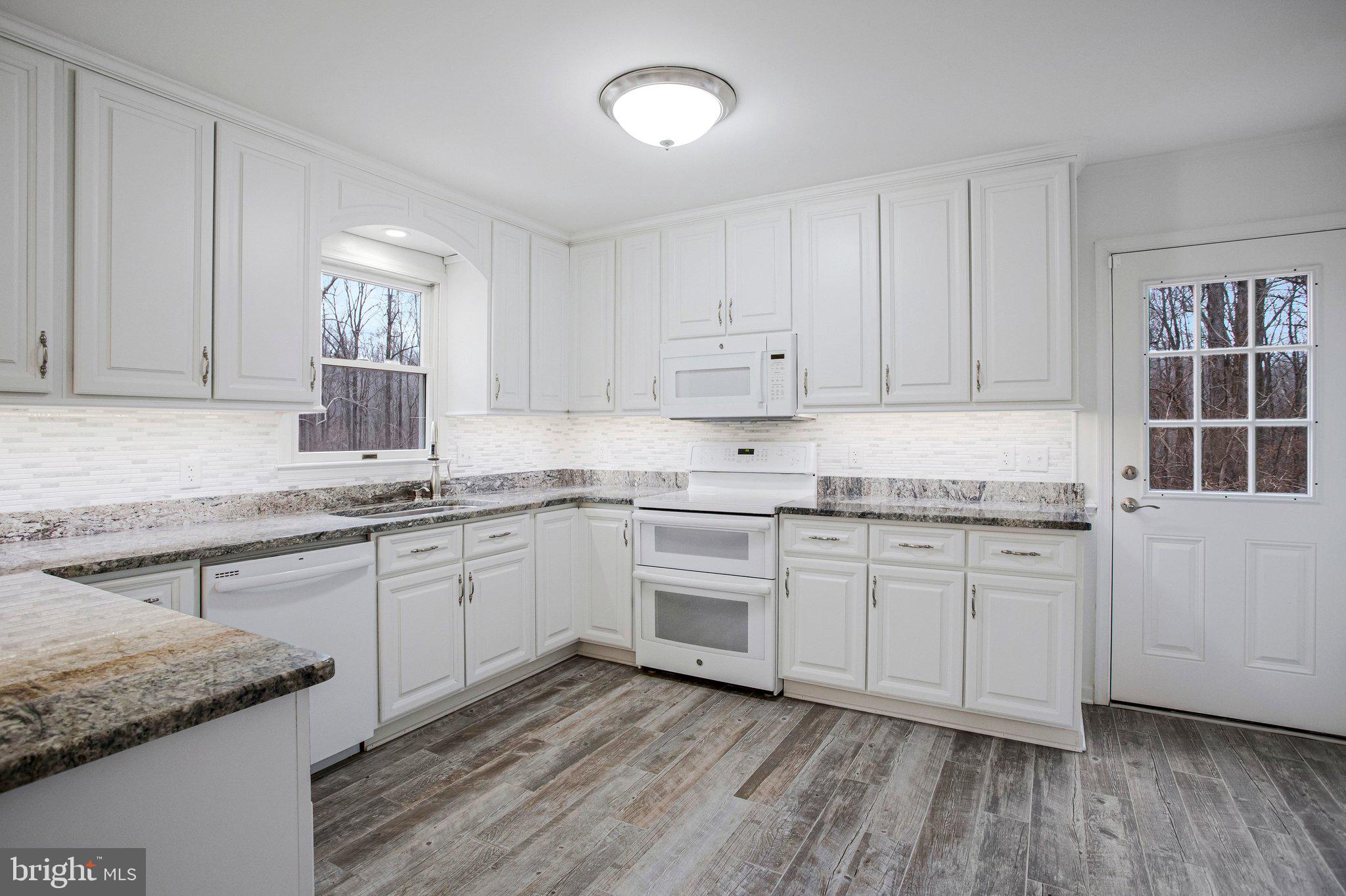 4350 Camp Kaufmann Road Huntingtown, MD 20639 - Photo 2 of 23 a kitchen with granite countertop cabinets sink and stainless steel appliances
