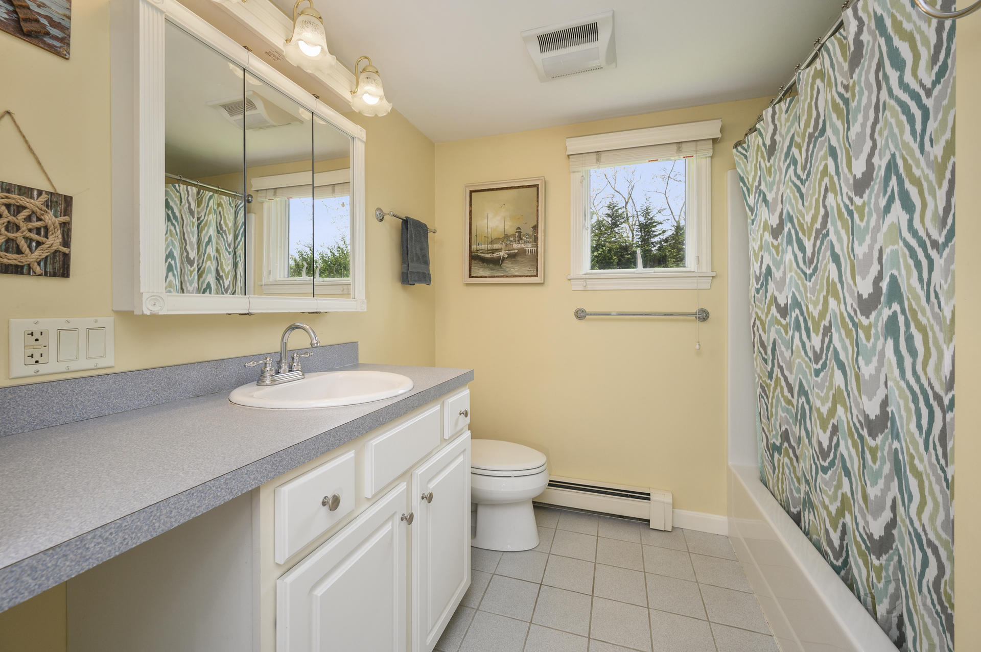 48 Locust Road Orleans, MA 02653 - Photo 19 of 36 a bathroom with a granite countertop sink mirror vanity and a toilet