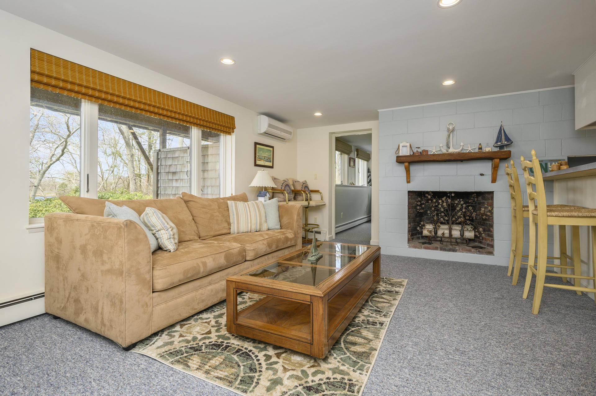 48 Locust Road Orleans, MA 02653 - Photo 24 of 36 a living room with furniture a large window and a fireplace