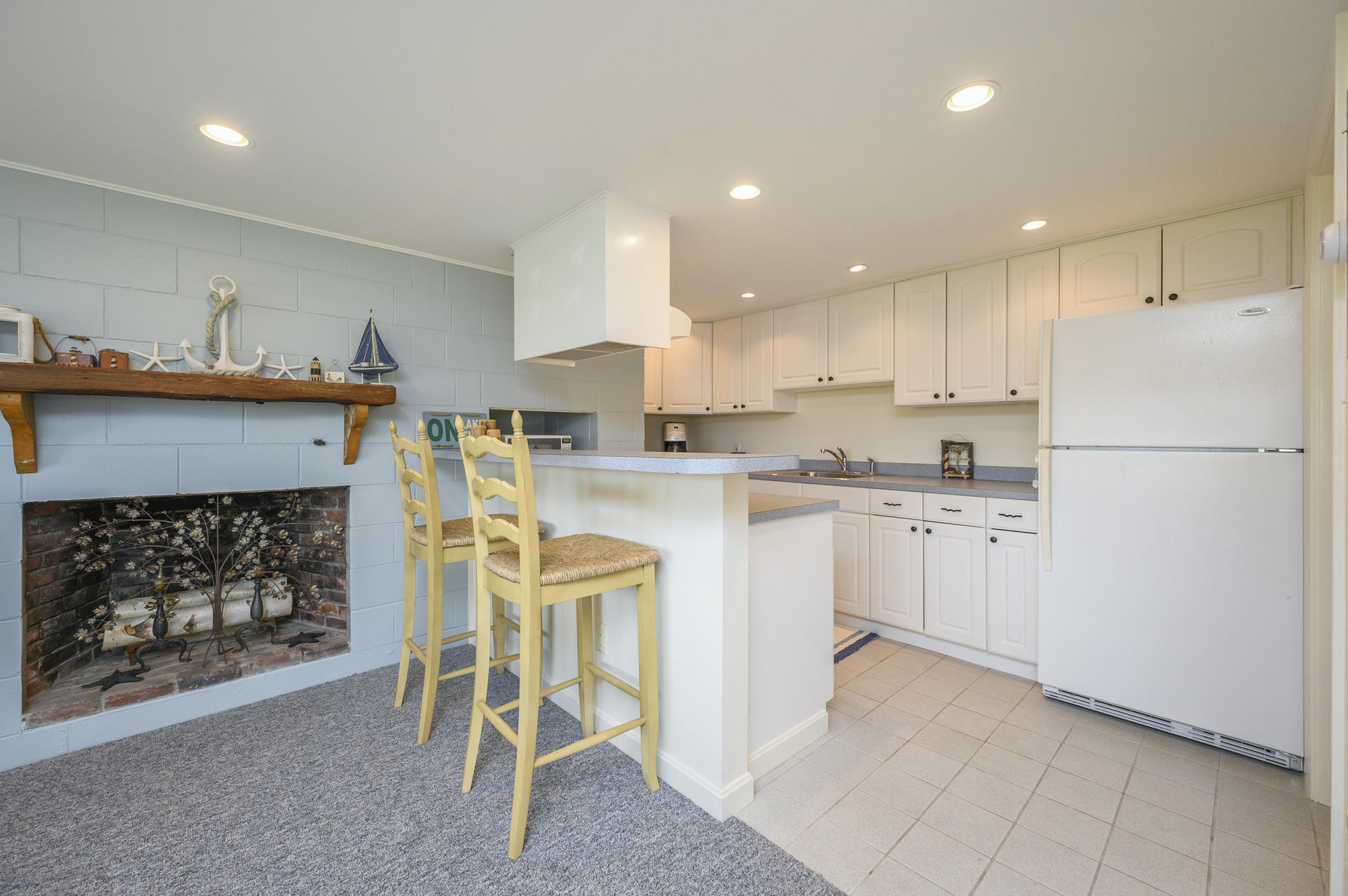 48 Locust Road Orleans, MA 02653 - Photo 26 of 36 a kitchen with white cabinets and white appliances
