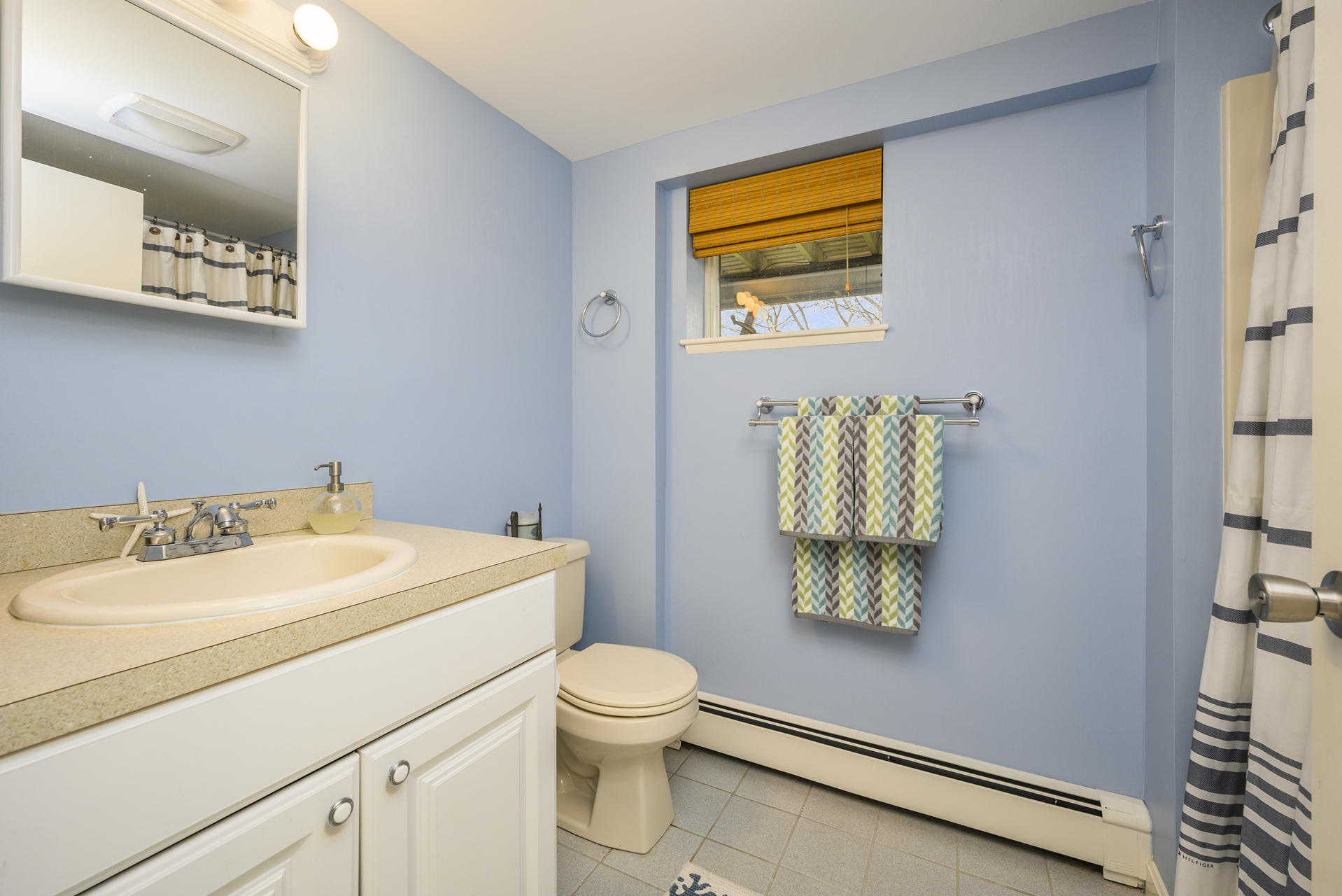 48 Locust Road Orleans, MA 02653 - Photo 27 of 36 a bathroom with a sink mirror vanity and toilet