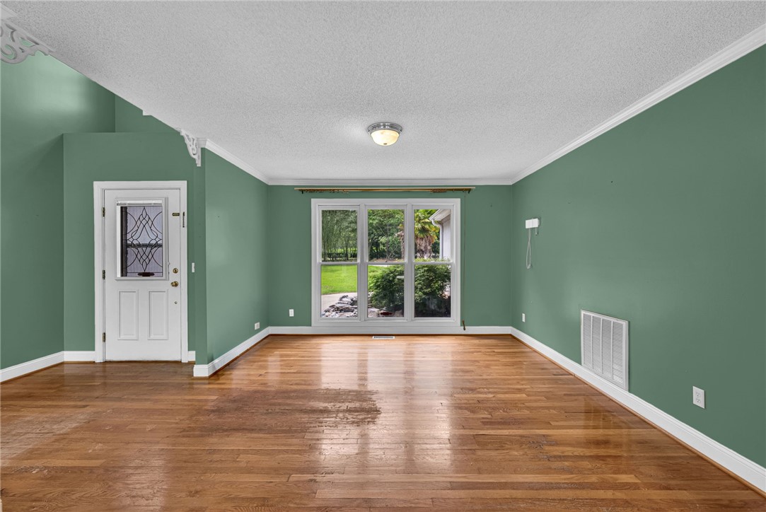 1016 Campbell Road Belton, SC 29627 - Photo 5 of 50 Hardwood floors stretch across this living space, offering views of the lush yard through wide windows.