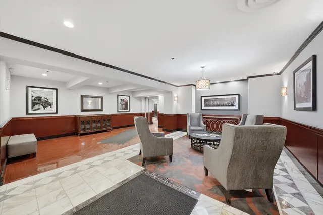 a living room with furniture a large window and bookshelf