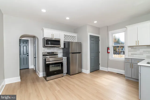 a kitchen with granite countertop a refrigerator and a stove top oven
