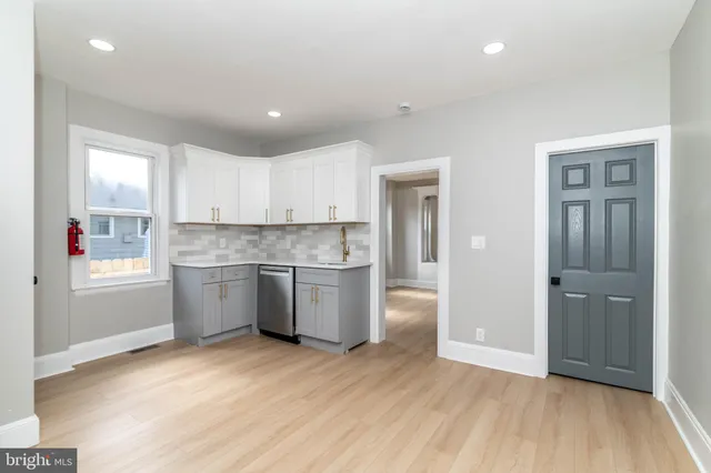 a kitchen with a refrigerator and white cabinets