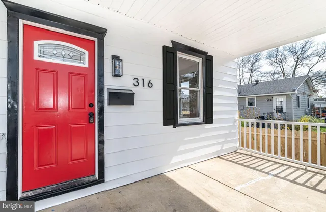 front view of a house with a red door and a large window