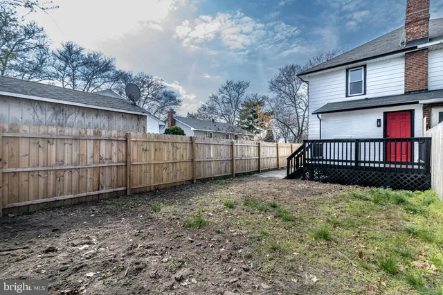 a view of a backyard with a large tree and wooden fence