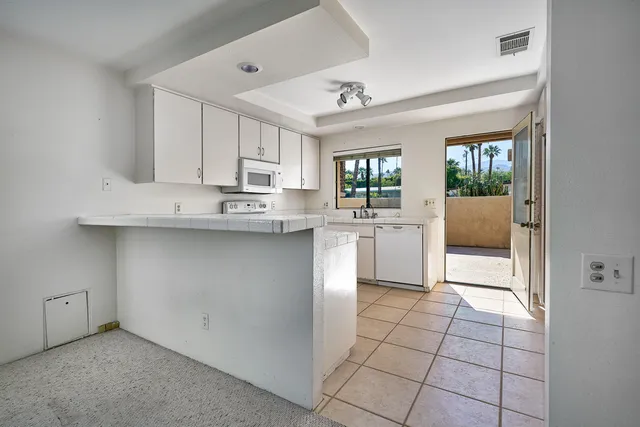 a kitchen with white cabinets appliances and a sink