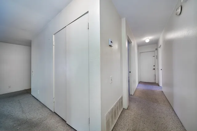 an empty room with fan and windows