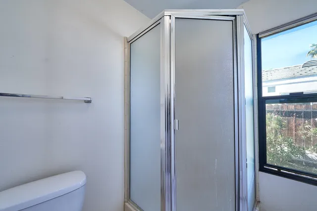 an empty room with windows and fan