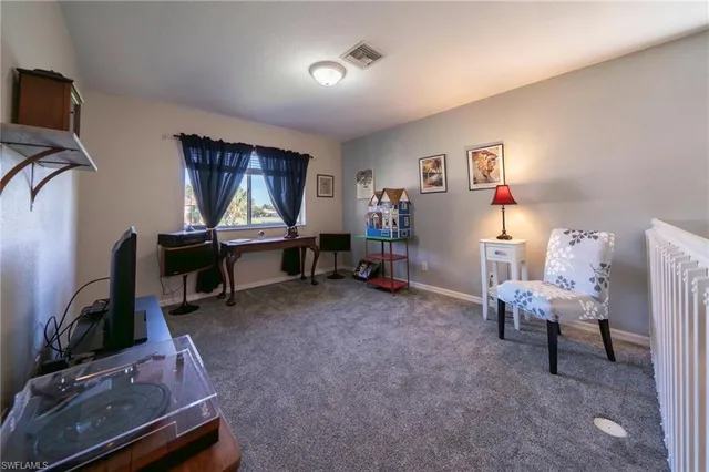a view of a workspace with furniture and a window