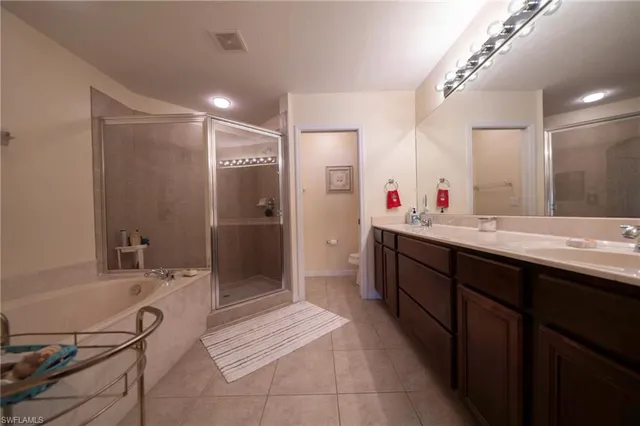 a bathroom with a double vanity sink a mirror and a shower
