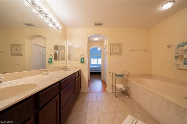 a spacious bathroom with a granite countertop sink a toilet and bathtub