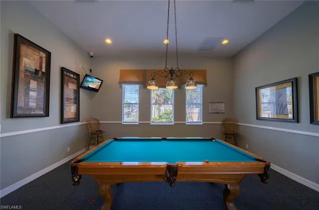a room with pool table and windows