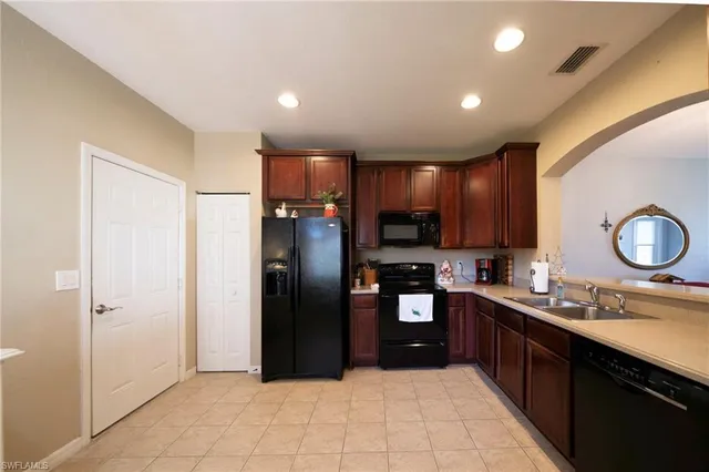 a large kitchen with a sink stainless steel appliances and cabinets