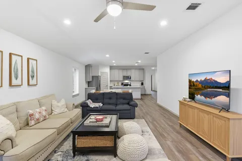 a living room with furniture and a wooden floor