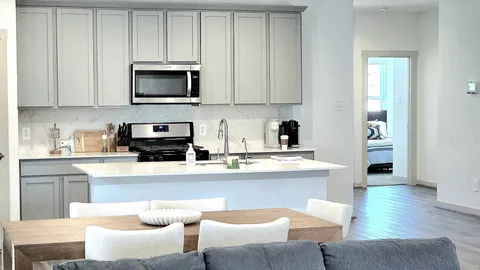 a kitchen with white cabinets sink and stainless steel appliances