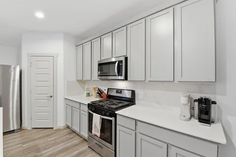 a kitchen with stainless steel appliances a sink stove and refrigerator