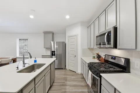 a living room with furniture and a refrigerator