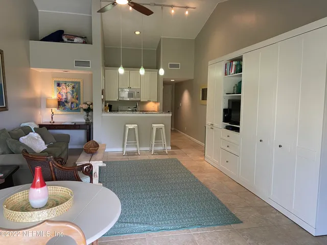 a kitchen with stainless steel appliances kitchen island granite countertop a table chairs and a refrigerator