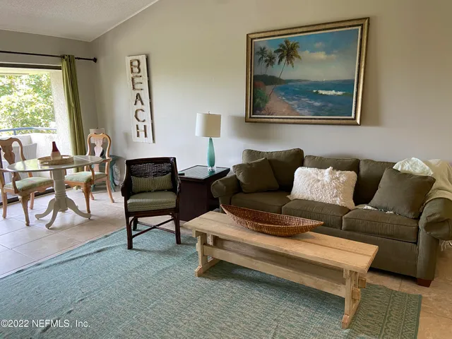 a living room with furniture and a painting on the wall