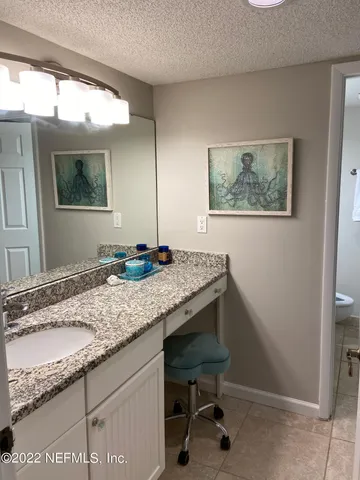 a bathroom with a granite countertop sink a mirror and vanity